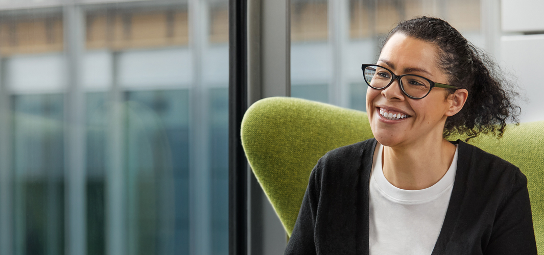 Karen 坐在綠色的椅子上微笑。