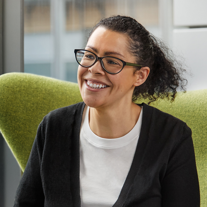 Karen 坐在綠色椅子上的特寫相片。