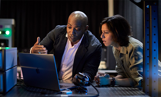 Mike és egy munkatársa egy MacBookot néznek egy laboratóriumban.