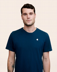 Ayakta durarak kameraya bakan Apple Retail çalışanı.