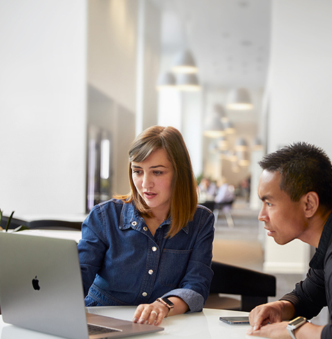 İş arkadaşıyla konuşan bir Apple Cork Destek ve Servis ekip üyesi.