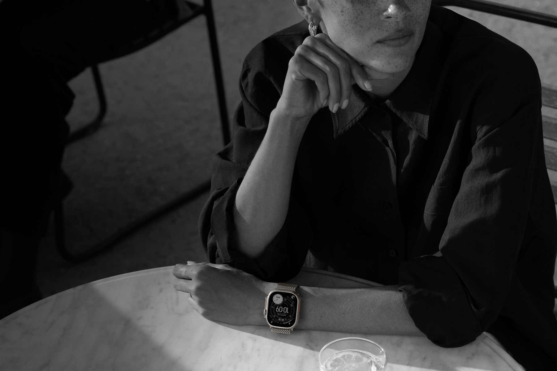 Osoba nosi Apple Watch Ultra 3 dok je na večeri