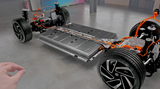 一隻手以兩指捏合的手勢與 3D 投影的汽車傳動系統進行互動