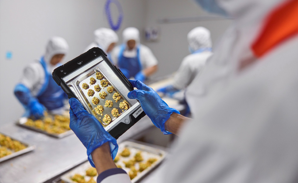 Zaměstnanec provádí kontrolu kvality na iPadu.