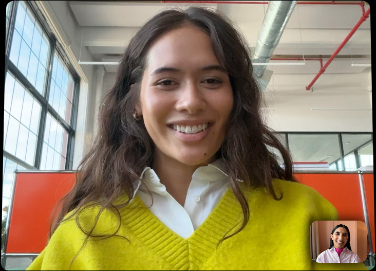 Un iPad Pro agganciato a una Magic Keyboard, aperto, mostrato di fronte, il display mostra una chiamata FaceTime a tutto schermo per mettere in evidenza il sistema di fotocamere Pro