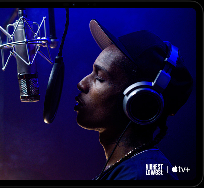 Un iPad Pro nero siderale in orizzontale visto di fronte, angoli arrotondati, cornice del display nera, sul display si vede una scena del film di Apple TV Plus Highest two Lowest con ASAP Rocky nei panni di Yung Felon che rappa in un microfono