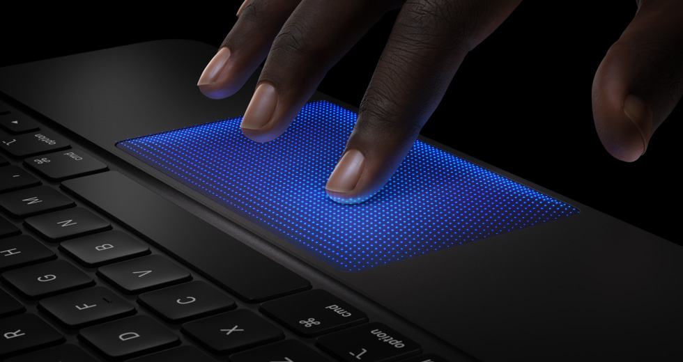 Animazione di una mano con le dita sul trackpad della Magic Keyboard, l’indice ha un’ombra blu a indicare il gesto del tocco per il feedback aptico