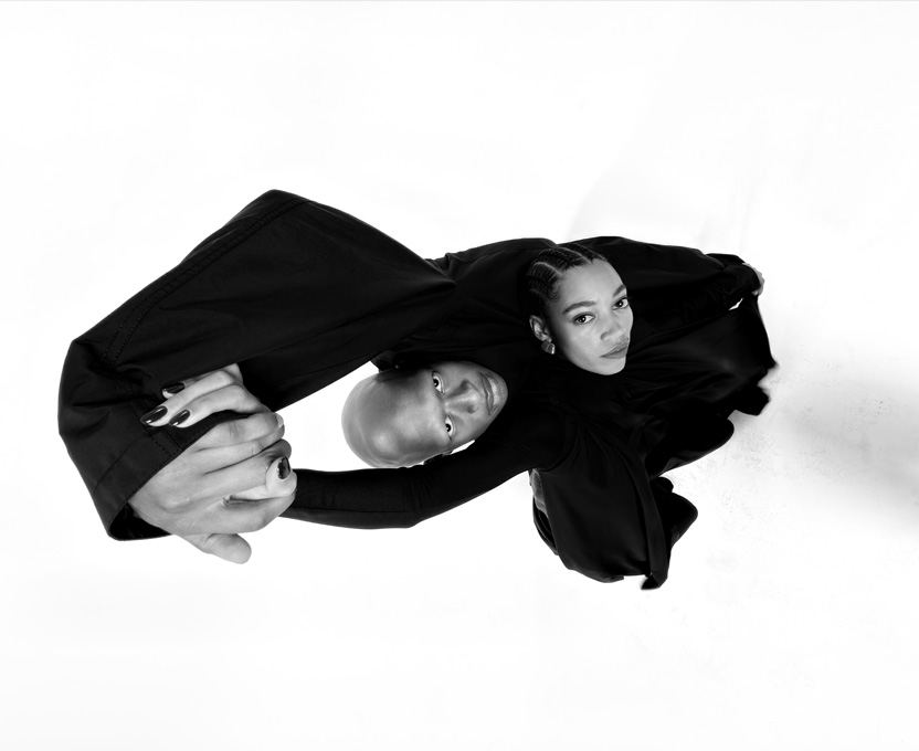 Μια ασπρόμαυρη φωτογραφία ευρείας γωνίας με δύο άτομα δείχνει τις δυνατότητες της κάμερας με Υπερευρυγώνιο φακό στο iPhone 17 Pro