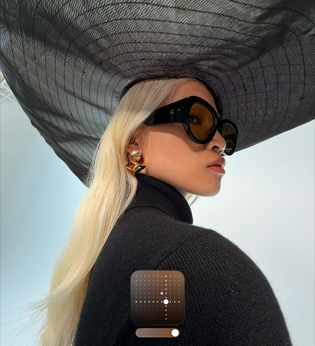 Retrato de una mujer con un sombrero negro de ala ancha que muestra el Estilo Fotográfico Brillante, que aumenta el brillo de las fotos tomadas en condiciones de poca luz o con el Modo Noche